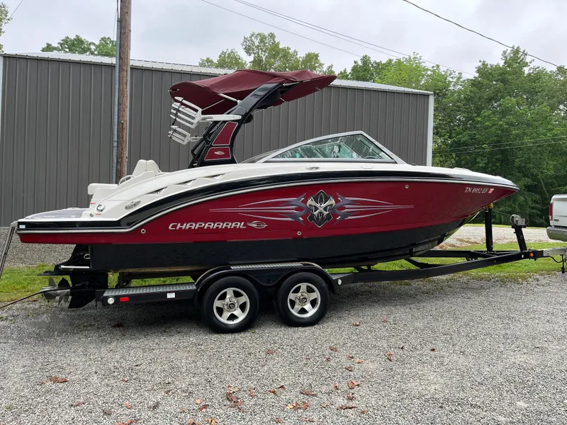 The Image of 2013 Chaparral 224 Xtreme boat on trailer, red and white design, parked outdoors. - 0