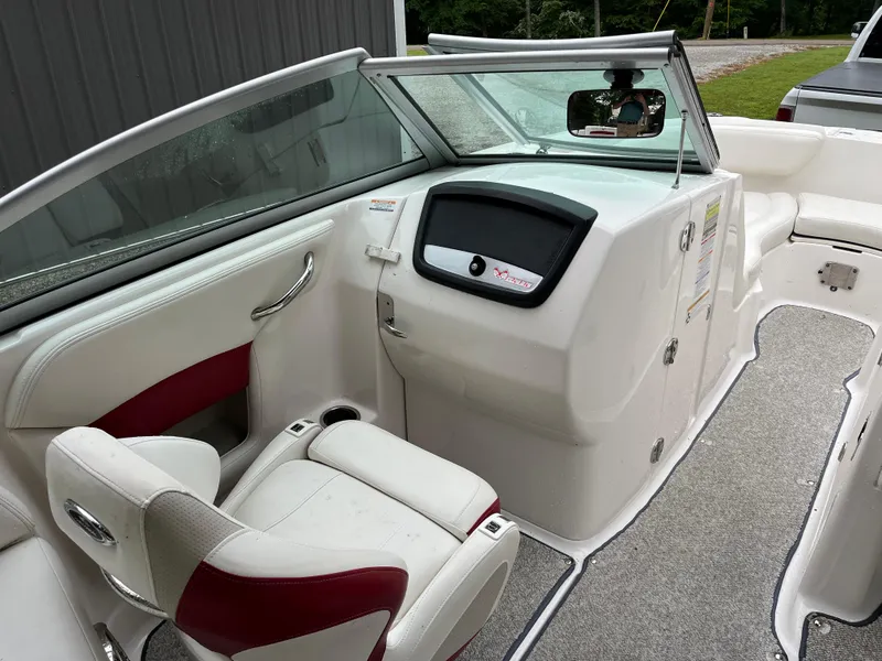 Slide: The Image of 2013 Chaparral 224 Xtreme boat interior with white and red seating, dashboard, and carpeted floor. - 13