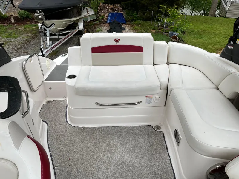 Slide: The Image of 2013 Chaparral 224 Xtreme boat interior with white and red seating, docked outdoors. - 15