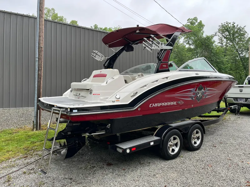 Slide: The Image of 2013 Chaparral 224 Xtreme boat on trailer, red and white design, parked outdoors. - 2