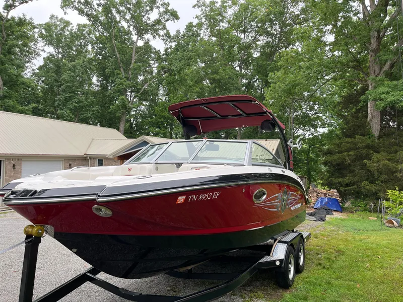 Slide: The Image of 2013 Chaparral 224 Xtreme boat on trailer, parked outdoors near trees and a house. - 3