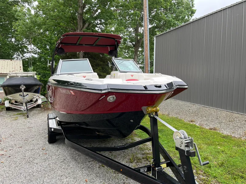Slide: The Image of 2013 Chaparral 224 Xtreme boat on trailer, red and black, parked outdoors. - 4