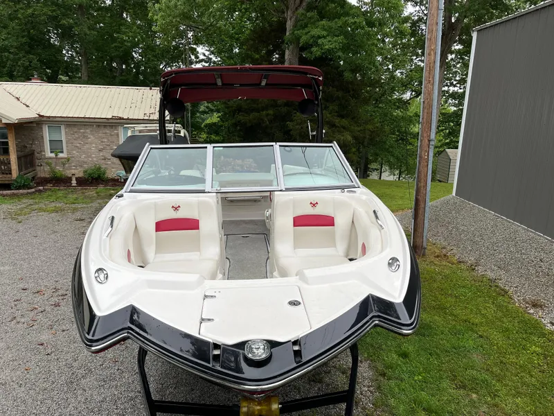 Slide: The Image of 2013 Chaparral 224 Xtreme boat with red and white interior, parked outdoors. - 5