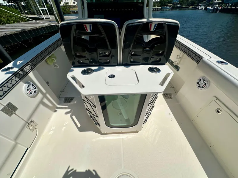 Slide: The Image of 2019 Wellcraft 262 Fisherman boat interior with dual seats and storage, docked by the water. - 10