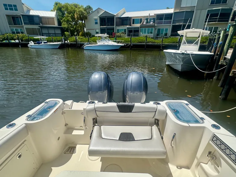 Slide: The Image of 2019 Wellcraft 262 Fisherman boat docked in a marina with twin engines. - 16