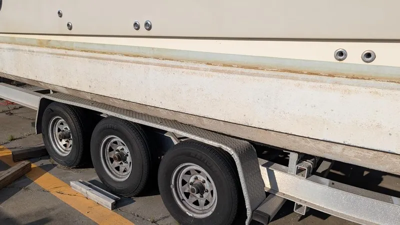 Slide: The Image of Trailer carrying a 2016 World Cat 320 DC boat, showing wheels and hull. - 15