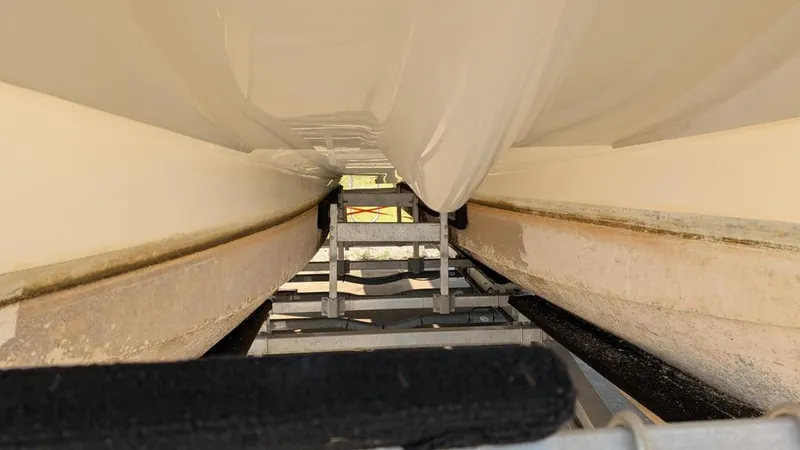 Slide: The Image of Underside view of a 2016 World Cat 320 DC boat on a trailer. - 16