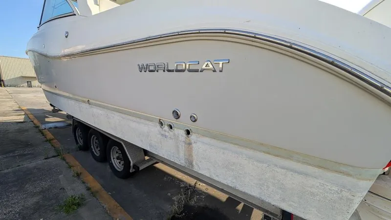 Slide: The Image of 2016 World Cat 320 DC boat on trailer, side view showing logo and hull. - 18
