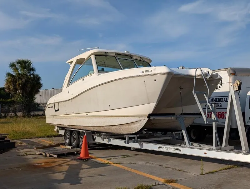 Slide: The Image of 2016 World Cat 320 DC boat on trailer, parked outdoors under clear sky. - 2