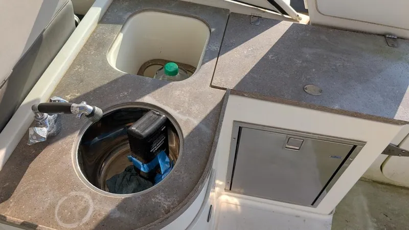 Slide: The Image of 2016 World Cat 320 DC boat interior with sink and storage area. - 5