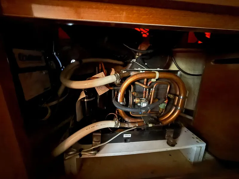 Slide: The Image of Engine compartment of a 2009 Sea Ray 250 Sundancer with visible pipes and components. - 10