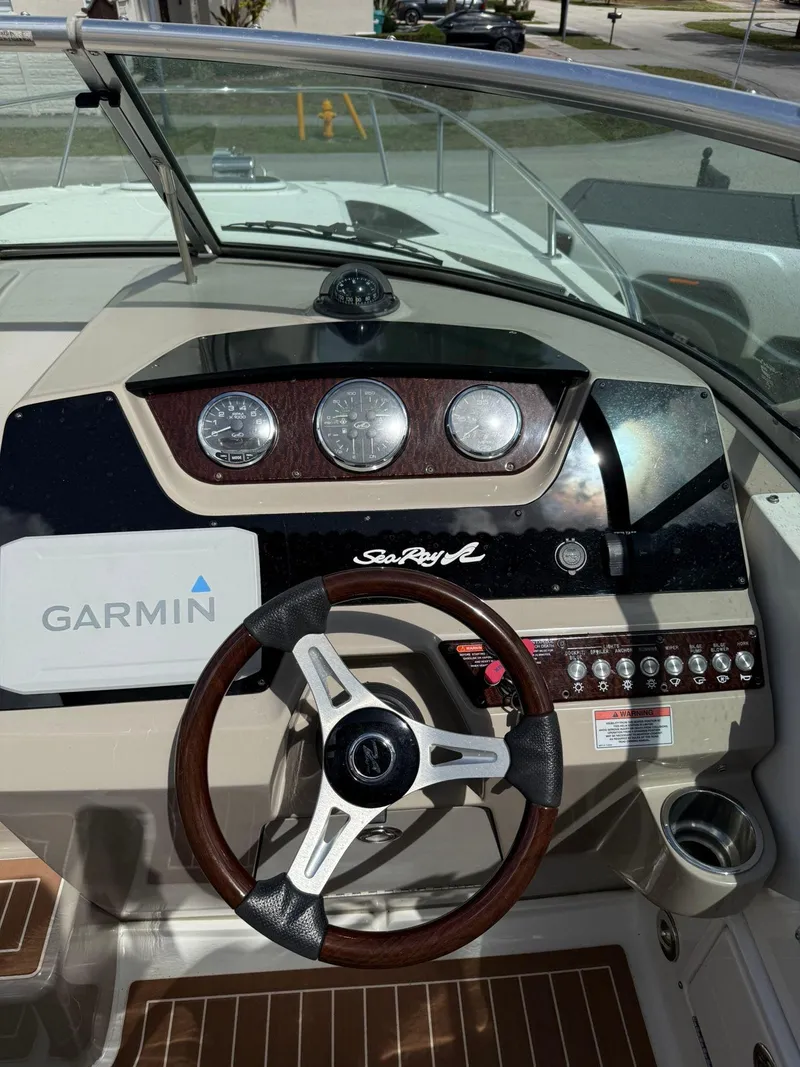 Slide: The Image of 2009 Sea Ray 250 Sundancer dashboard with Garmin navigation and wood accents. - 3