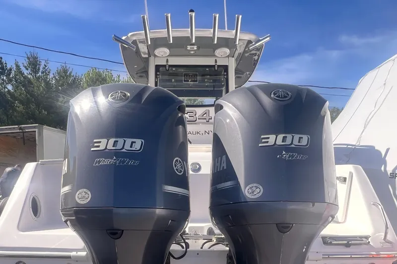 Slide: The Image of 2015 Everglades 295 Pilot boat with twin Yamaha 300 engines, docked under clear skies. - 2