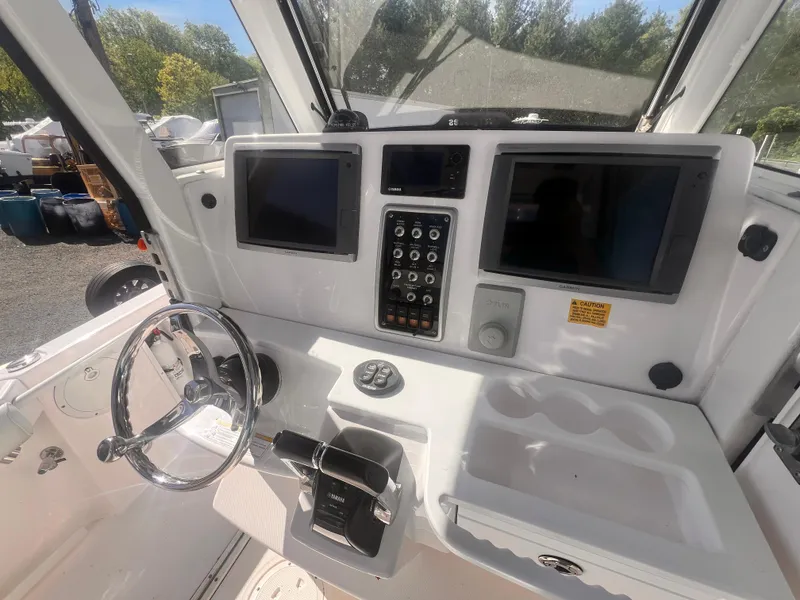 Slide: The Image of 2015 Everglades 295 Pilot boat dashboard with dual screens and control panel. - 6