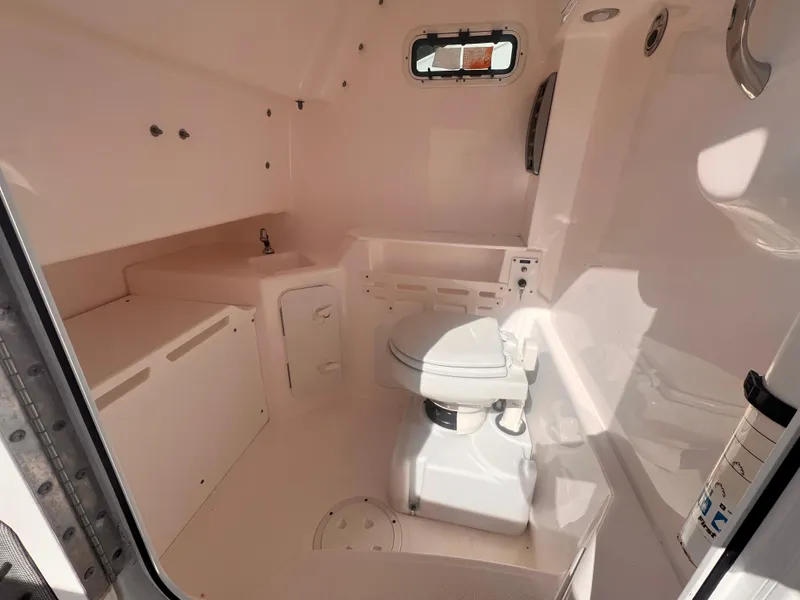 Slide: The Image of Interior of 2015 Everglades 295 Pilot boat, featuring a compact marine toilet. - 9