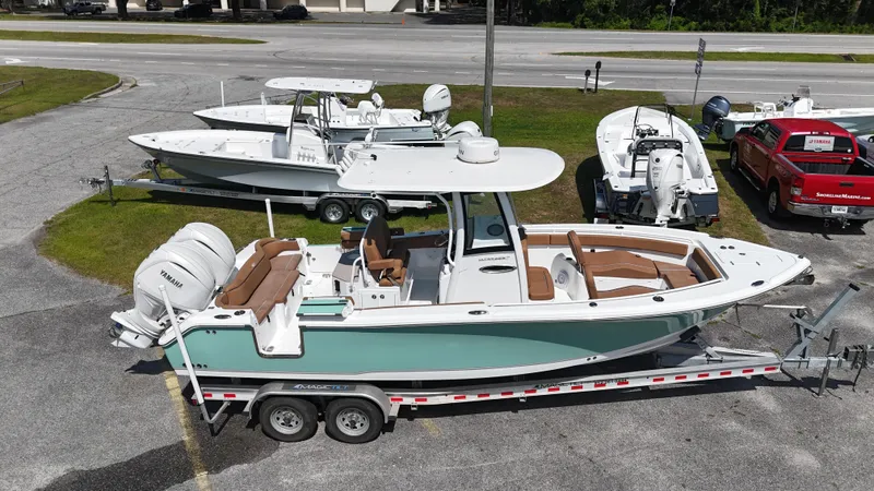 Slide: The Image of 2024 Sea Hunt Ultra 265 SE boat on trailer, parked with other boats in a lot. - 3