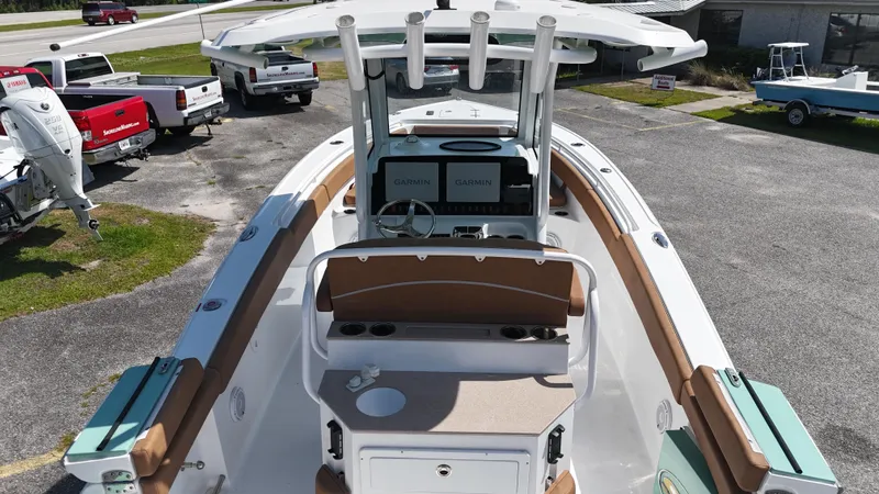 Slide: The Image of 2024 Sea Hunt Ultra 265 SE boat with modern console and seating, parked outdoors. - 7