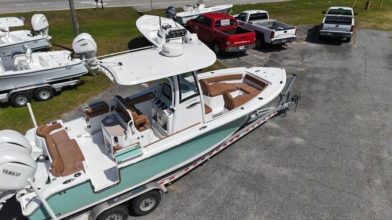 Slide: The Image of 2024 Sea Hunt Ultra 265 SE boat on trailer, parked in a lot with other vehicles. - 9