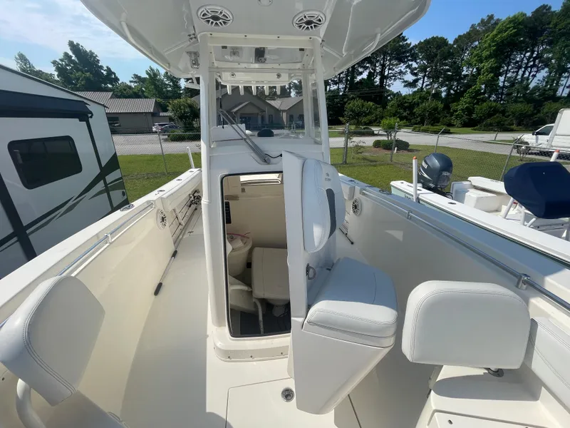 Slide: The Image of 2020 Cobia 262 Center Console boat with white interior and outdoor setting. - 12