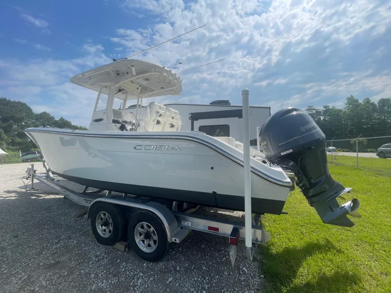 Slide: The Image of 2020 Cobia 262 Center Console boat on trailer under a partly cloudy sky. - 3