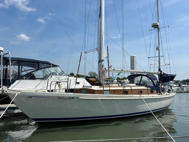 The Image of 1955 Hinckley 36 Auxiliary Yawl sailboat docked at marina under clear sky. - 0