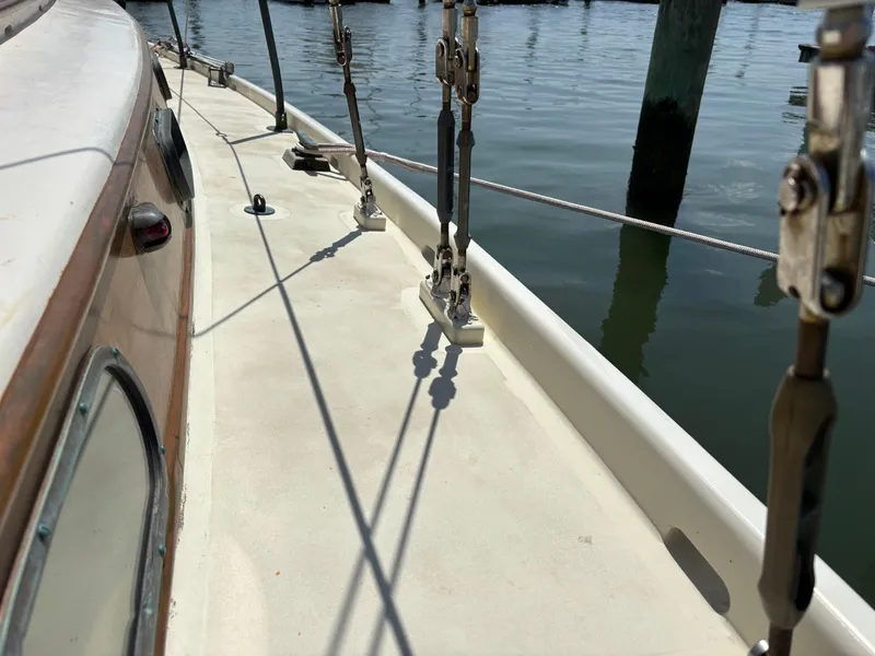 Slide: The Image of Hinckley 36 Auxiliary Yawl deck, 1955 model, showing rigging and calm water reflection. - 12