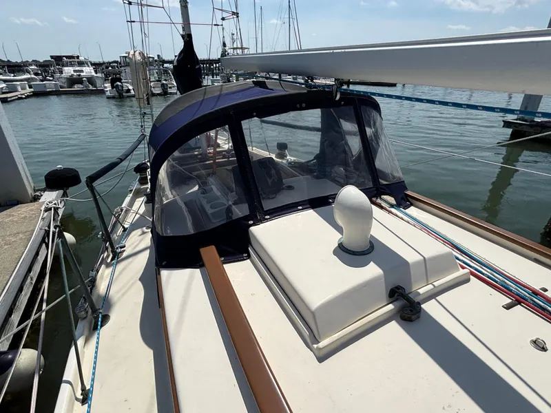 Slide: The Image of 1955 Hinckley 36 Auxiliary Yawl docked at marina, featuring classic design and blue canopy. - 15