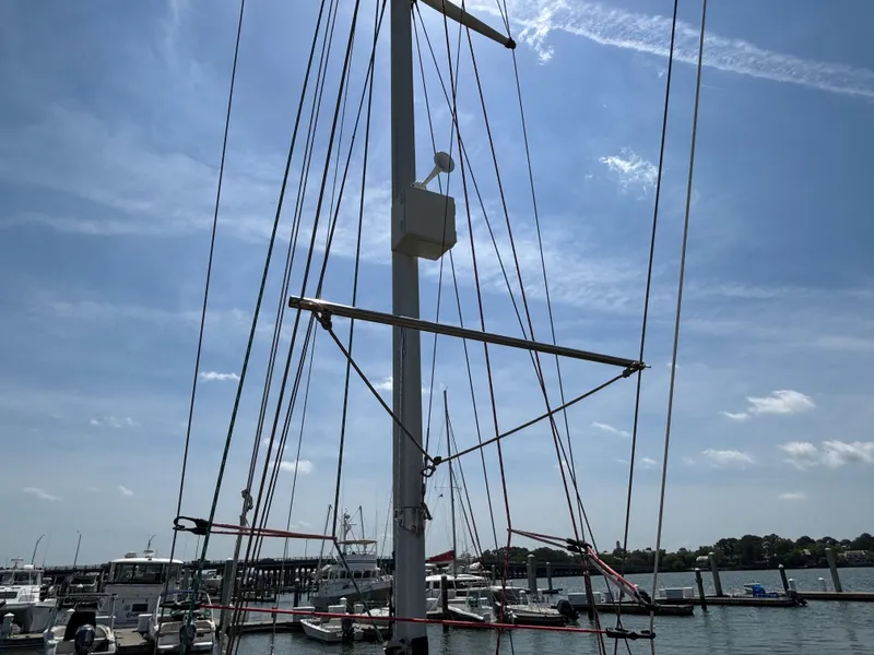 Slide: The Image of Hinckley 36 Auxiliary Yawl mast against a clear sky at a marina, 1955 model. - 20