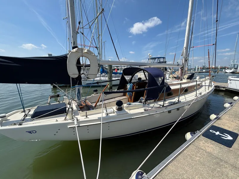 Slide: The Image of 1955 Hinckley 36 Auxiliary Yawl docked at a marina under a clear blue sky. - 4