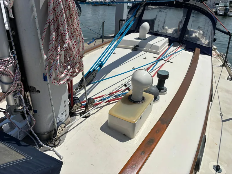 Slide: The Image of 1955 Hinckley 36 Auxiliary Yawl deck with ropes and winches in a marina setting. - 9
