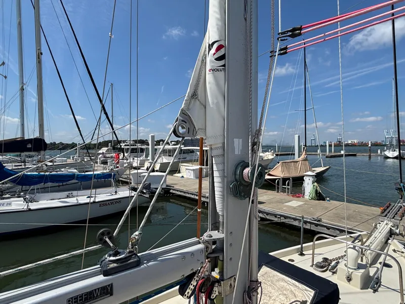 Slide: The Image of Hinckley 36 Auxiliary Yawl, 1955, docked at marina with clear blue sky. - 14