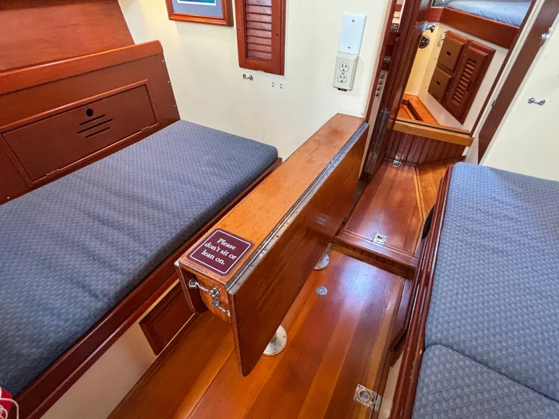 Slide: The Image of Interior of 1955 Hinckley 36 Auxiliary Yawl with wooden furnishings and blue cushions. - 38