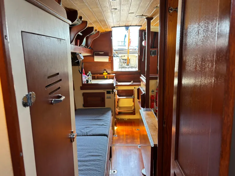 Slide: The Image of Interior of 1955 Hinckley 36 Auxiliary Yawl, featuring wooden finishes and cozy cabin space. - 39