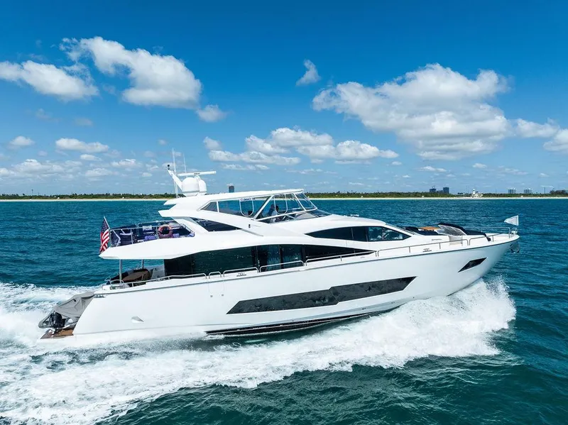 The Image of 2019 Sunseeker 86 Yacht cruising on open water with city skyline in background. - 0