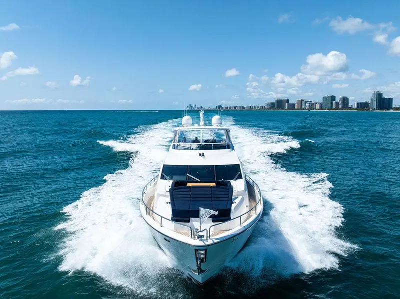 Slide: The Image of 2019 Sunseeker 86 Yacht cruising near a city skyline on a sunny day. - 1