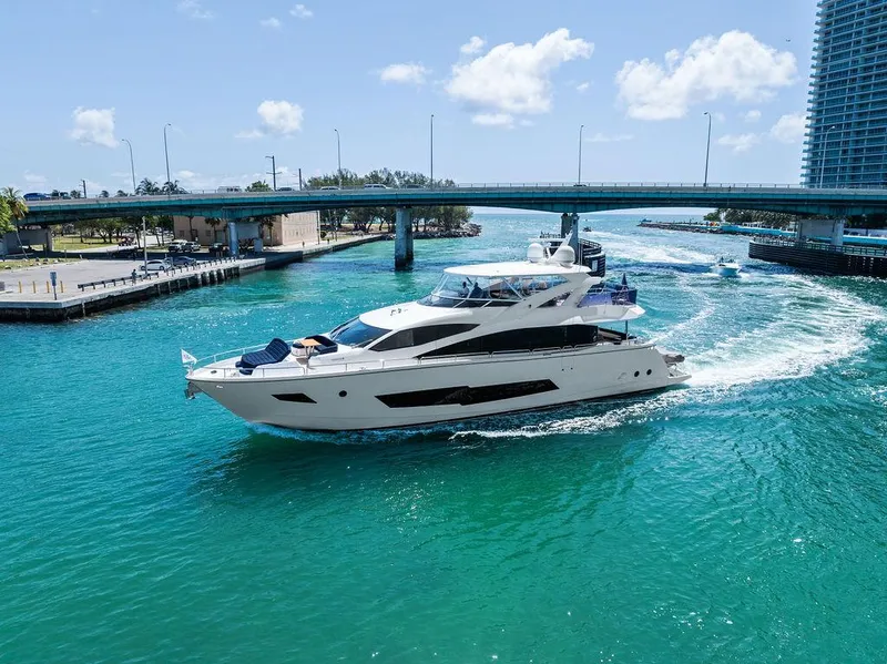 Slide: The Image of Luxurious 2019 Sunseeker 86 Yacht cruising under a bridge in clear blue waters. - 10