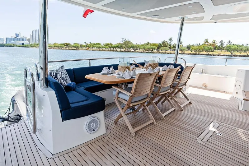 Slide: The Image of Luxurious 2019 Sunseeker 86 Yacht deck with elegant dining setup and scenic waterfront view. - 20