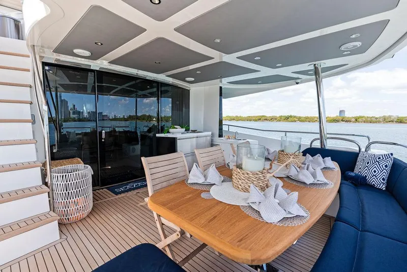 Slide: The Image of Luxurious 2019 Sunseeker 86 Yacht deck with elegant dining setup and scenic water view. - 24