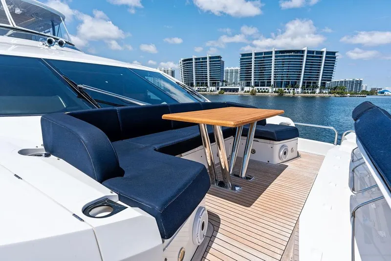 Slide: The Image of Luxurious 2019 Sunseeker 86 Yacht deck with seating and table, overlooking waterfront buildings. - 48