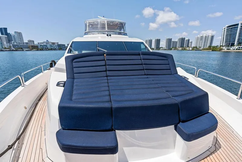 Slide: The Image of 2019 Sunseeker 86 Yacht with blue sunbed, city skyline in background. - 49