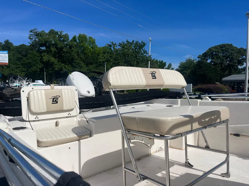 Slide: The Image of 2017 Carolina Skiff 178 DLV boat with white seating, outdoors under clear blue sky. - 11