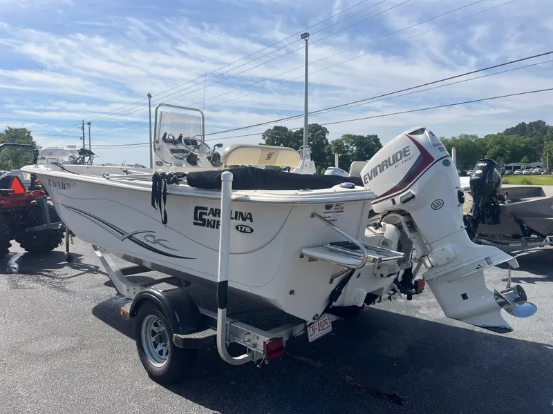 Slide: The Image of 2017 Carolina Skiff 178 DLV boat with Evinrude motor on trailer, parked outdoors. - 3