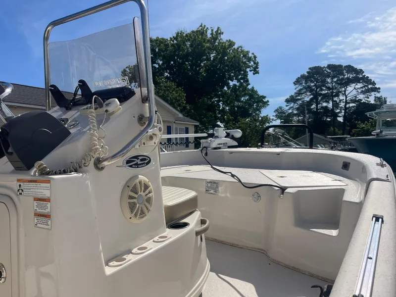 Slide: The Image of 2017 Carolina Skiff 178 DLV boat interior with steering console and seating, under clear blue sky. - 5