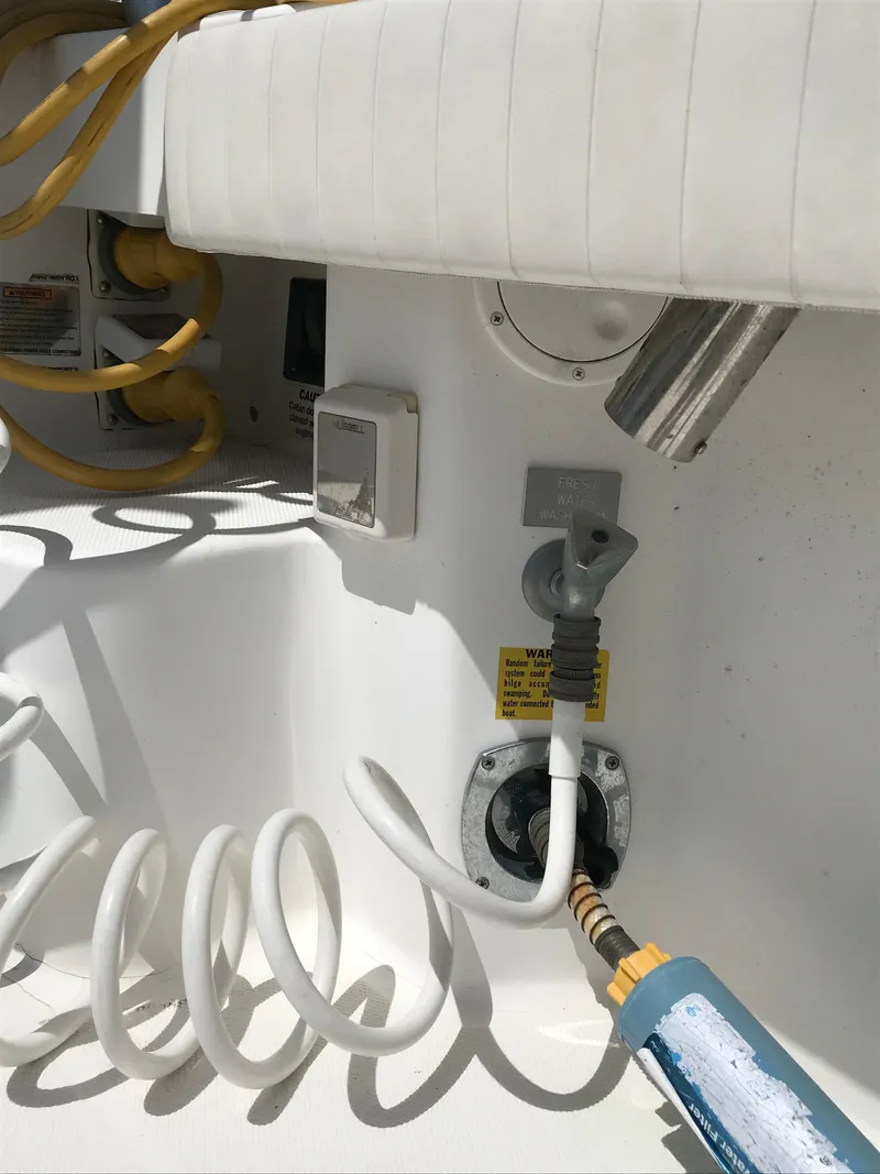 Slide: The Image of 2005 Rampage 30' Express Sportfish boat deck with coiled hose and electrical connections. - 10