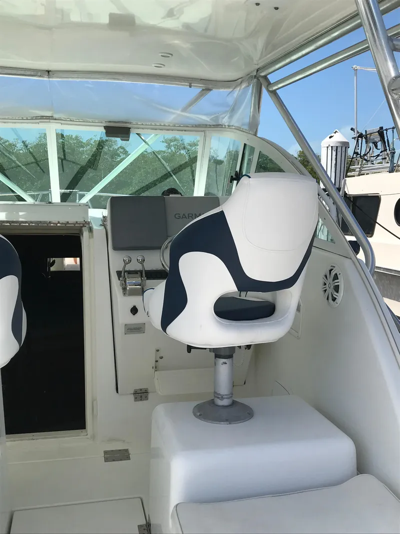 Slide: The Image of 2005 Rampage 30' Express Sportfish boat interior with helm and seating. - 13