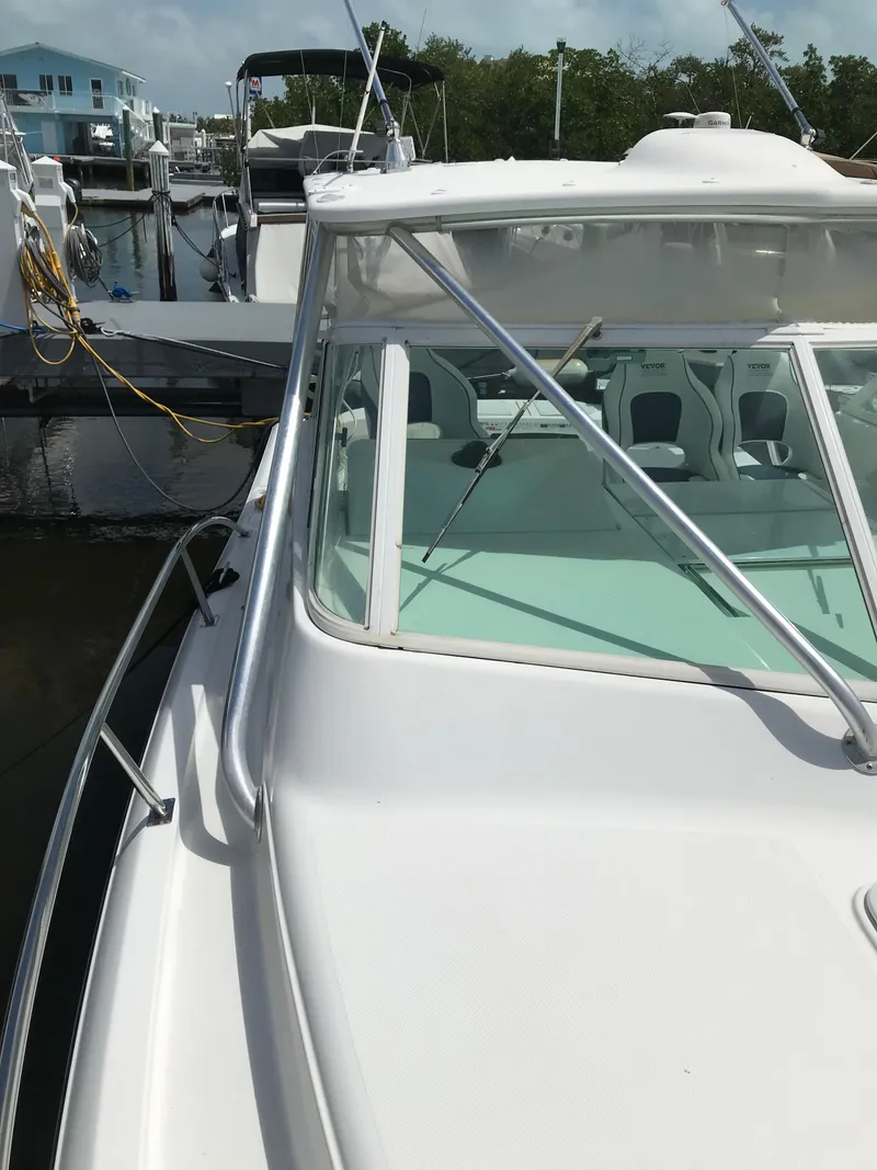 Slide: The Image of 2005 Rampage 30' Express Sportfish boat docked, featuring sleek design and spacious cockpit. - 30
