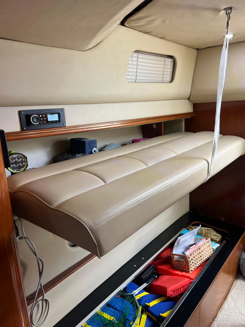Slide: The Image of 2005 Rampage 30' Express Sportfish cabin interior with beige seating and storage. - 45