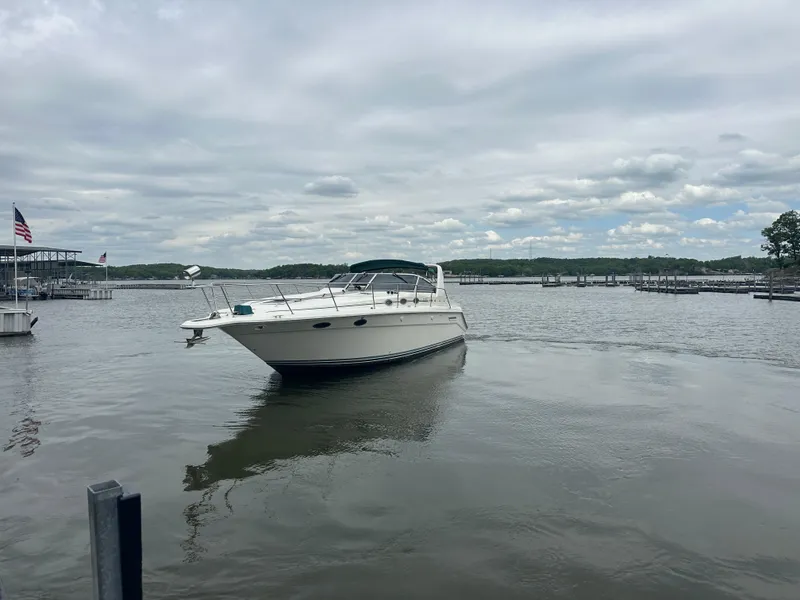 Slide: The Image of Sea Ray 370 Express Cruiser 1994 on a calm lake under cloudy skies. - 10