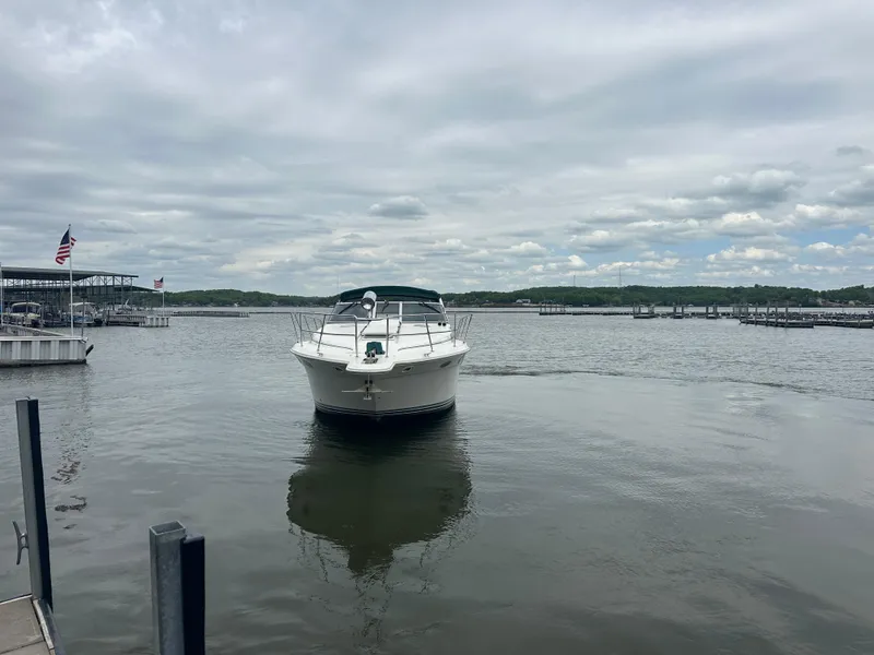 Slide: The Image of 1994 Sea Ray 370 Express Cruiser on a calm lake under cloudy skies. - 11