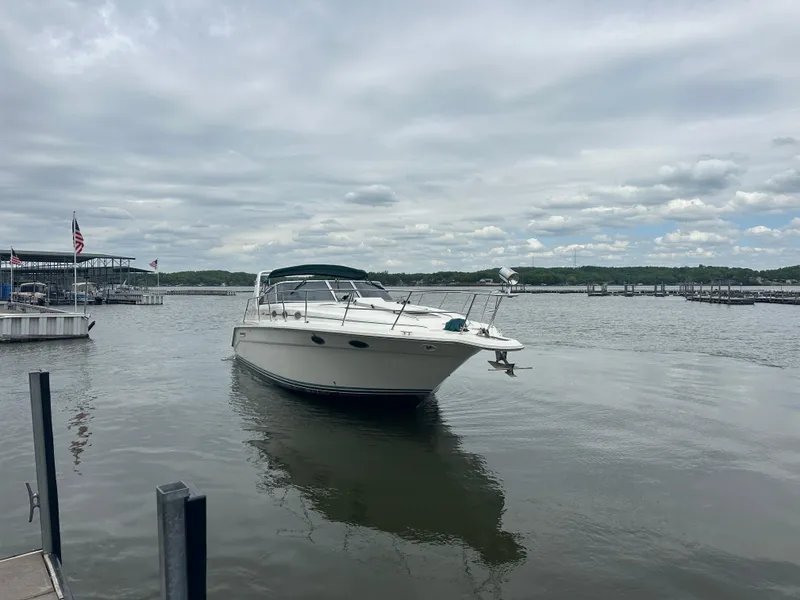 Slide: The Image of 1994 Sea Ray 370 Express Cruiser on calm water under cloudy sky. - 12